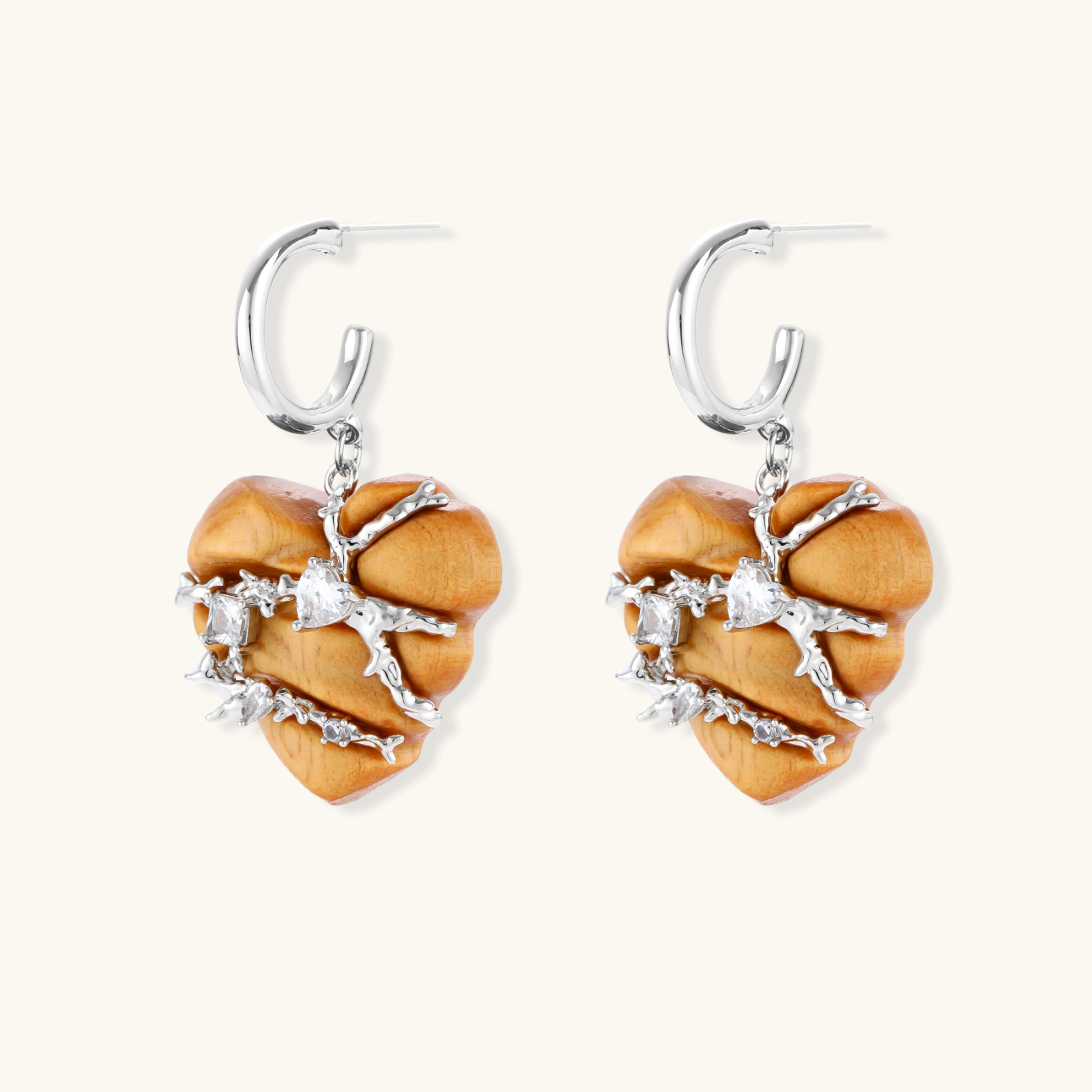 Heart-shaped wood earrings wrapped in silver wire with zirconia crystals, featuring ball stud posts on white background.