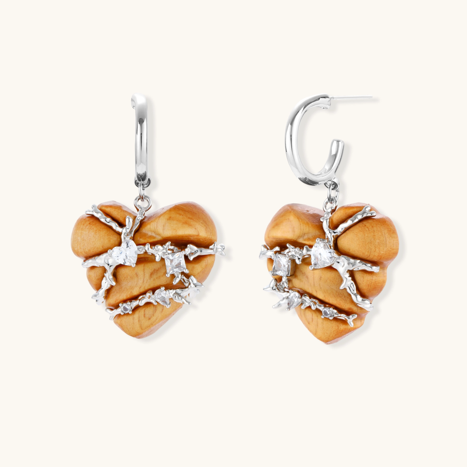 Heart-shaped wood earrings wrapped in silver wire with zirconia crystals, featuring ball stud posts on white background.