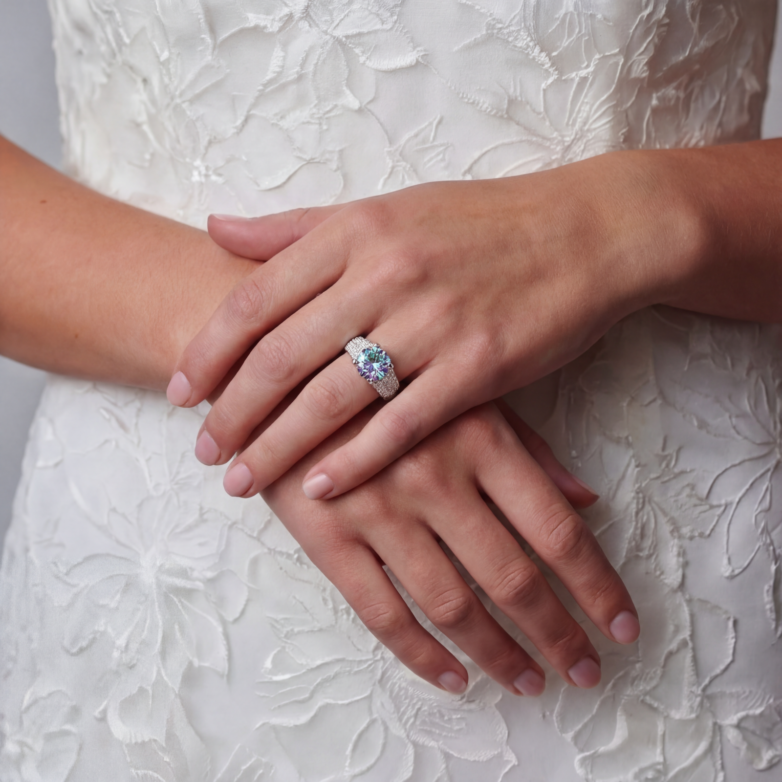 Sterling silver adjustable ring with brilliant round moissanite center stone and pavé diamond band showing rainbow fire