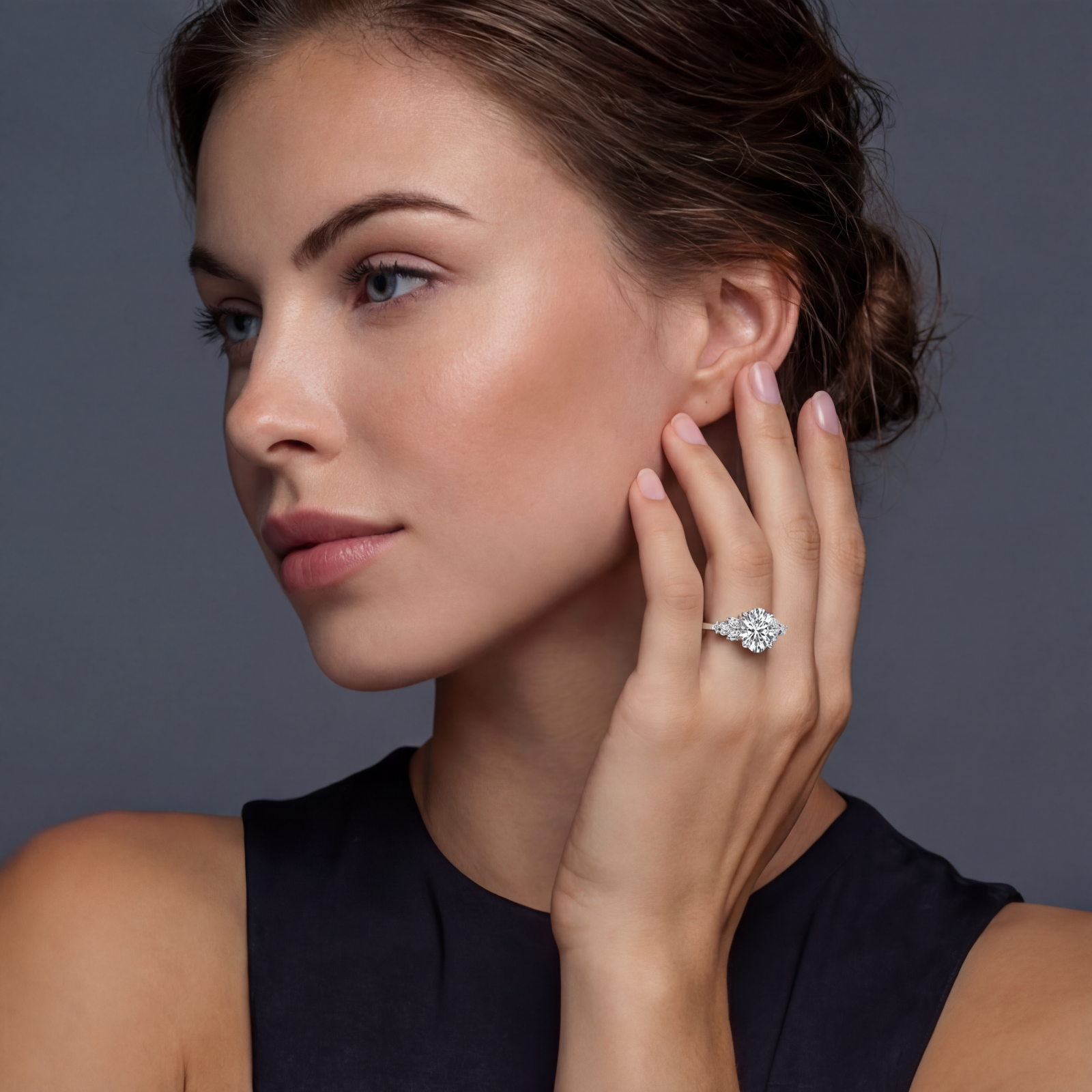 Sterling silver ring with oval moissanite center stone surrounded by smaller accent stones in ornate setting