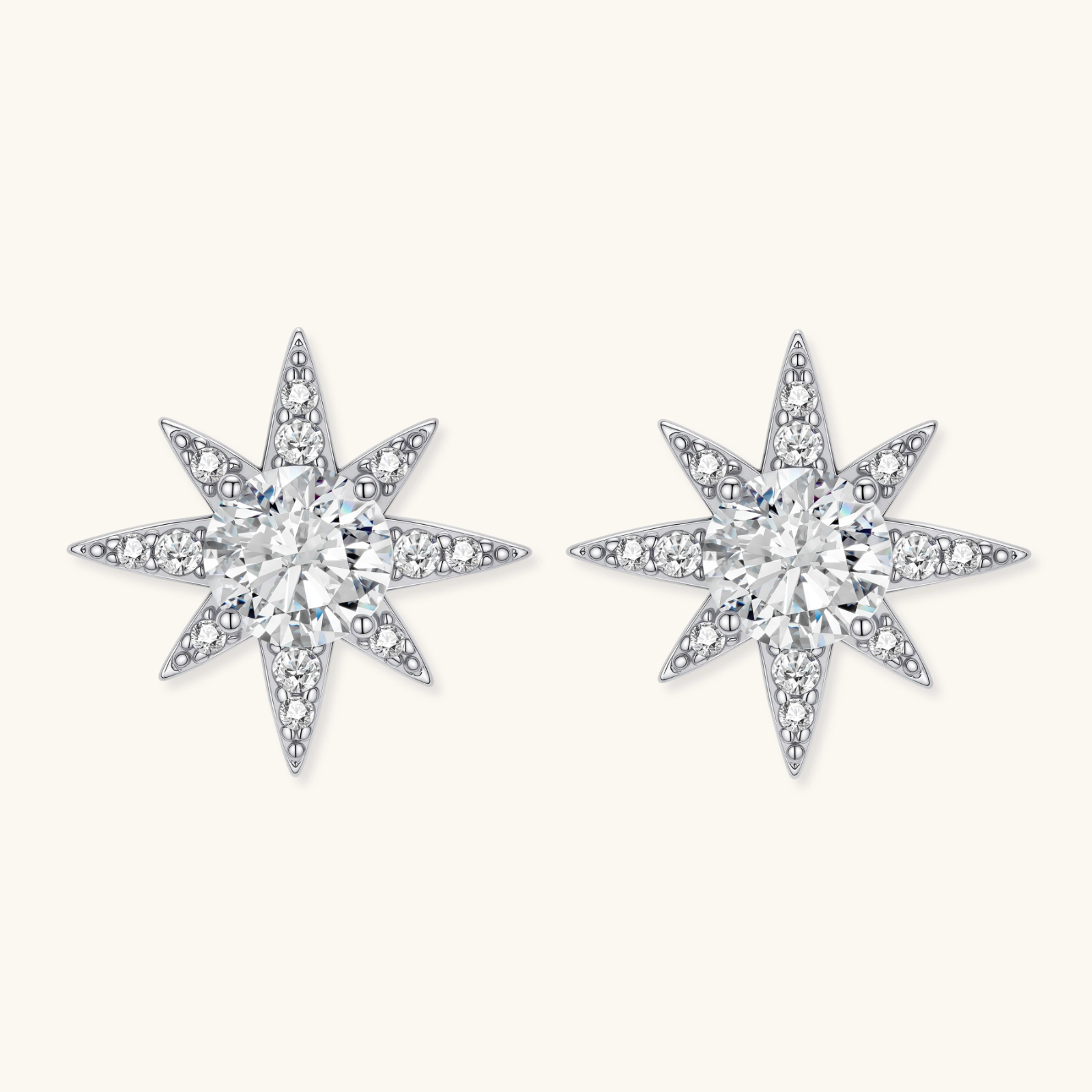 Sterling silver star-shaped stud earrings with brilliant moissanite center stones and pavé details on neutral background.