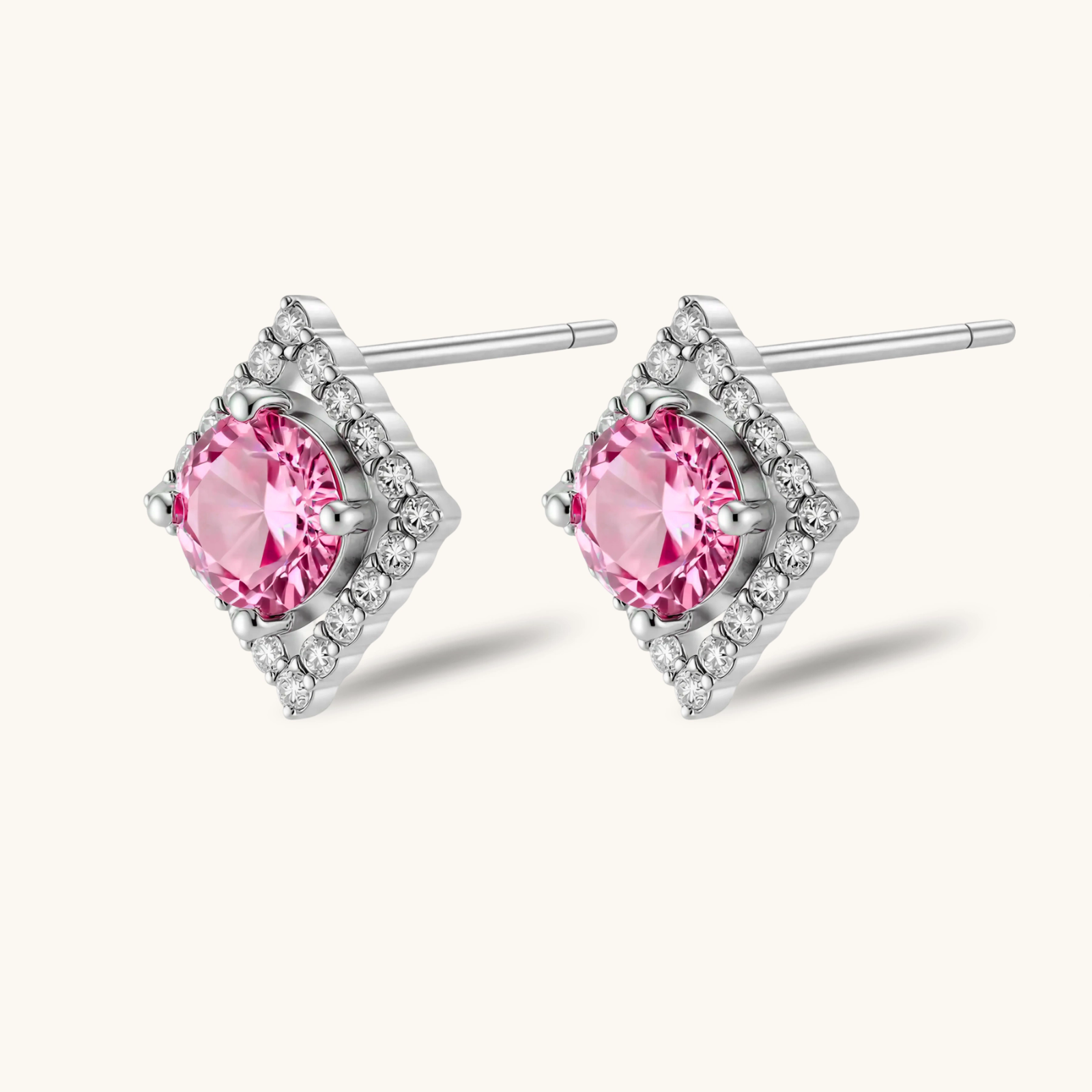 Sterling silver diamond-shaped stud earrings with pink moissanite center stones and crystal halo setting on white background