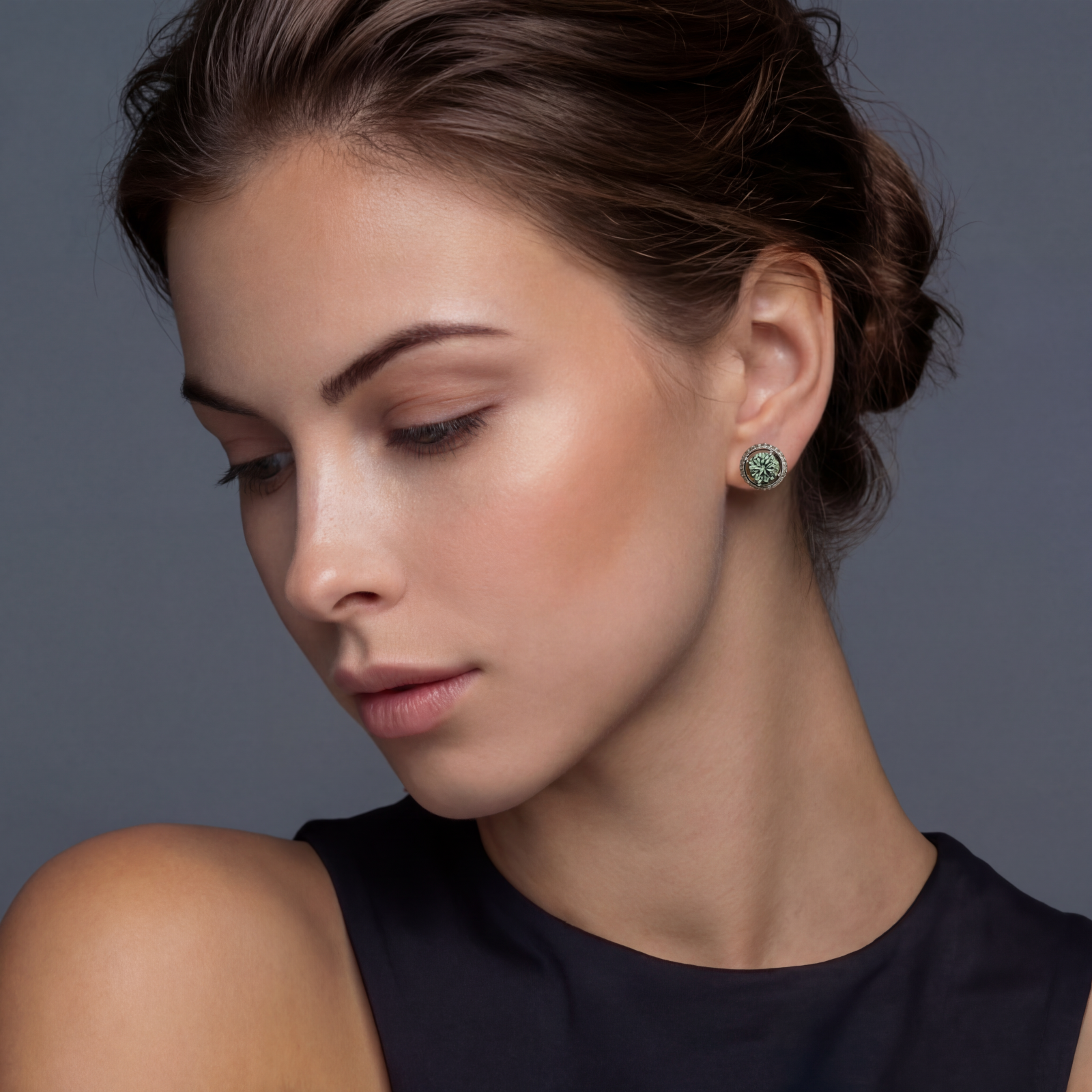 Round green moissanite stud earrings in sterling silver halo settings with brilliant sparkle on white background.