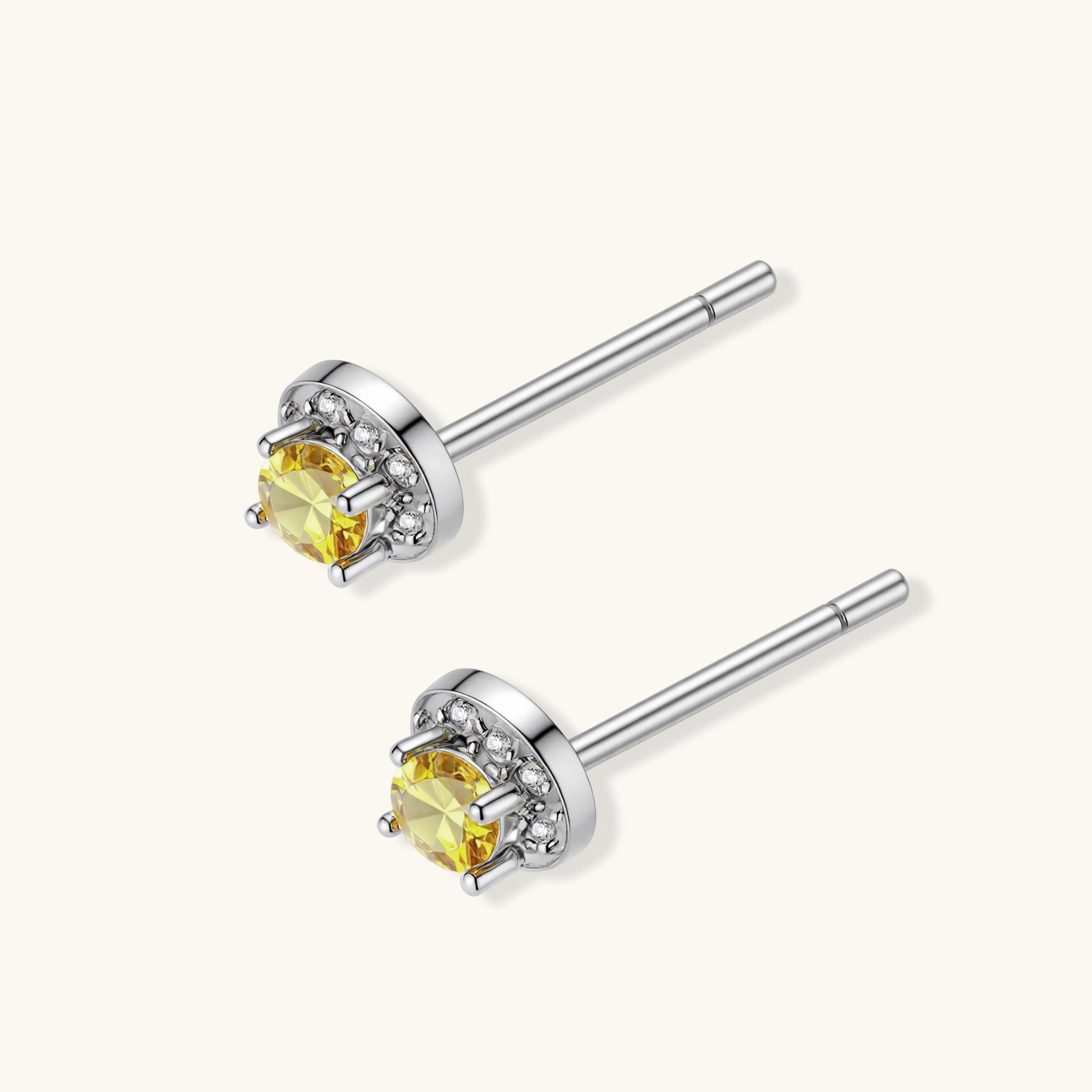 Dainty sterling silver stud earrings with yellow moissanite center stones surrounded by white halo stones