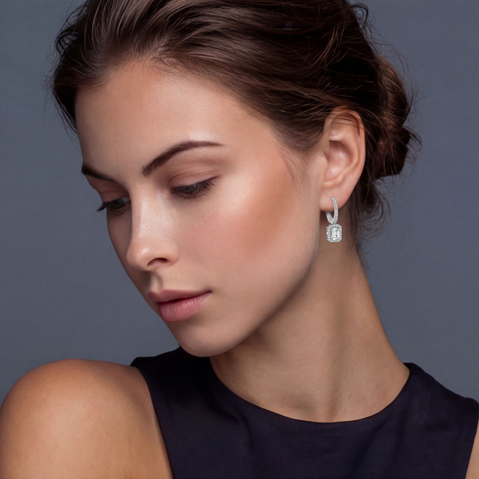 Sterling silver huggie hoops with emerald-cut moissanite drops featuring pavé-set crystals on white background.