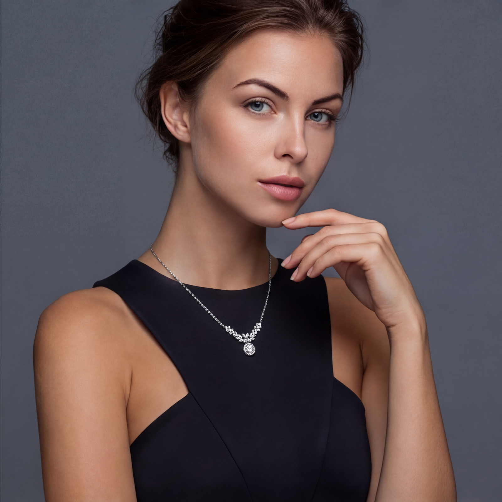 Elegant sterling silver necklace featuring intricate wing-like design with brilliant moissanite stones on neutral background.