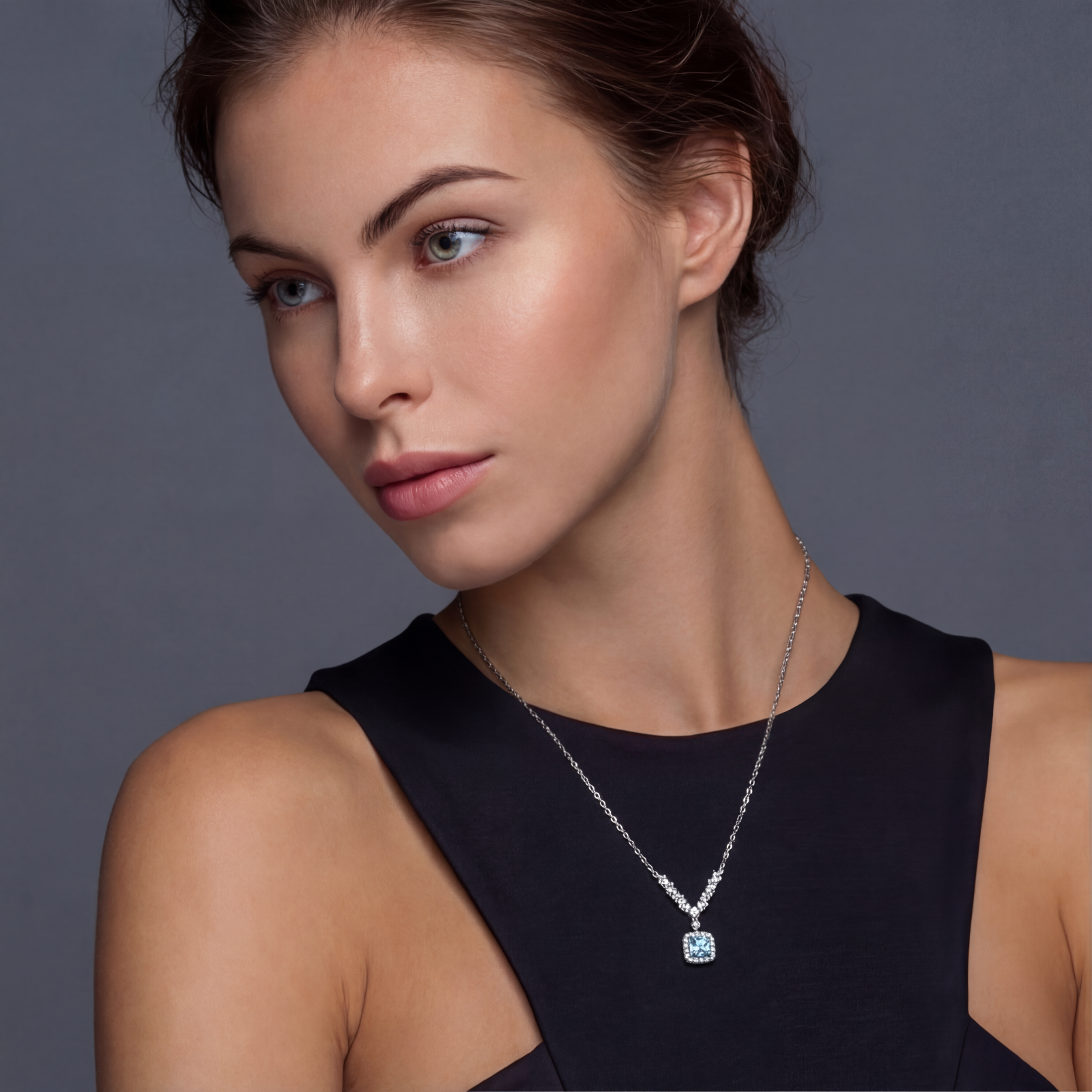 Sterling silver necklace with geometric crystal arrangement forming a V-shape and square blue moissanite centerpiece pendant