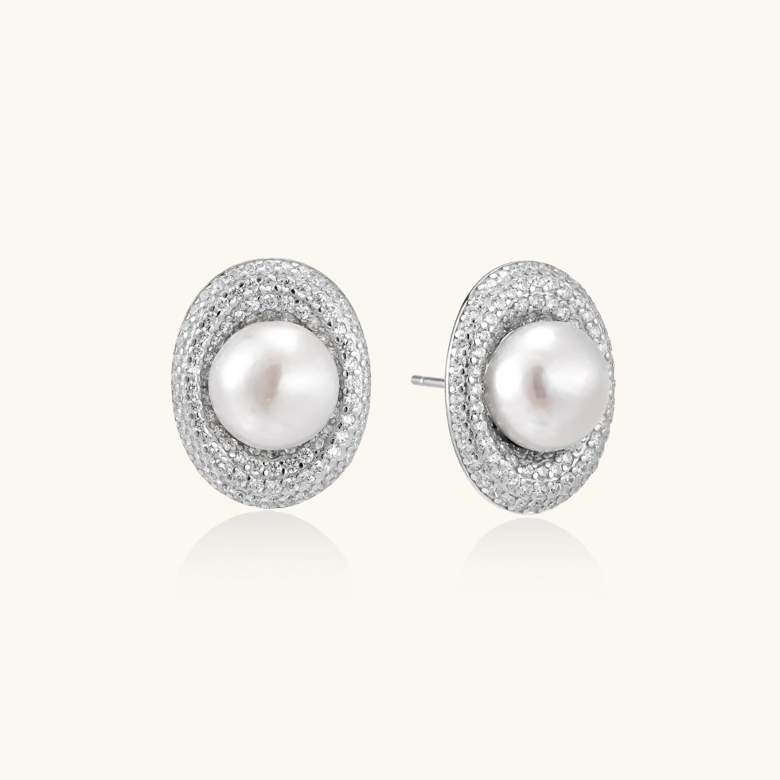 Elegant stud earrings with cream freshwater pearls surrounded by sparkly pavé crystals on rhodium-plated silver setting