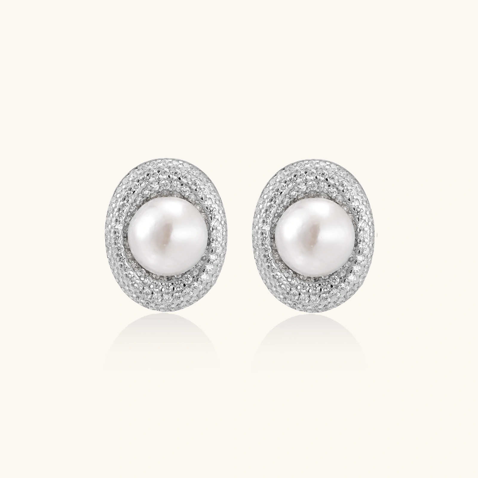 Elegant stud earrings with cream freshwater pearls surrounded by sparkly pavé crystals on rhodium-plated silver setting