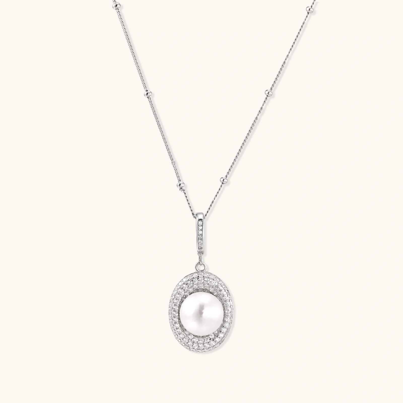 Oval sterling silver pendant with crystal halo surrounding a white freshwater pearl on delicate chain