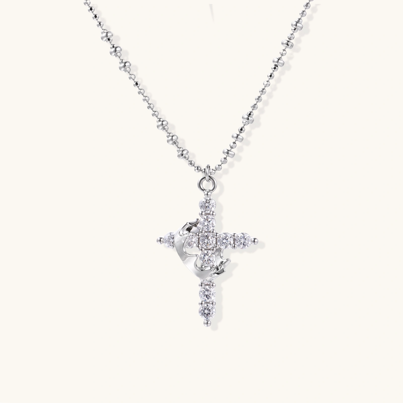 White gold-plated cross pendant adorned with sparkling zirconia stones and crescent moon accent on ball chain