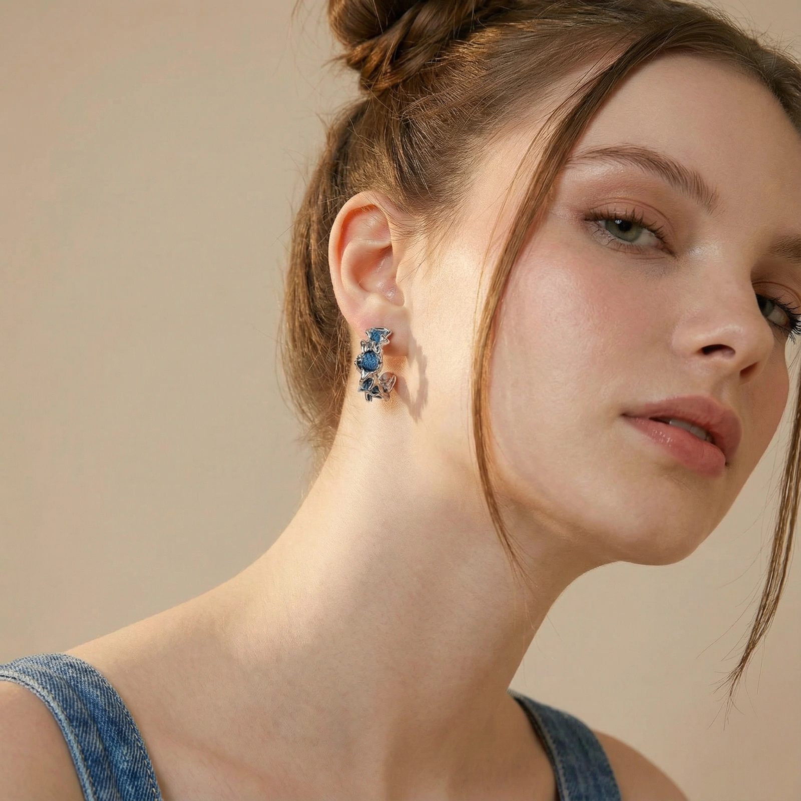 White gold plated hoop earrings with woven blue denim fabric through organic branch-like metal framework