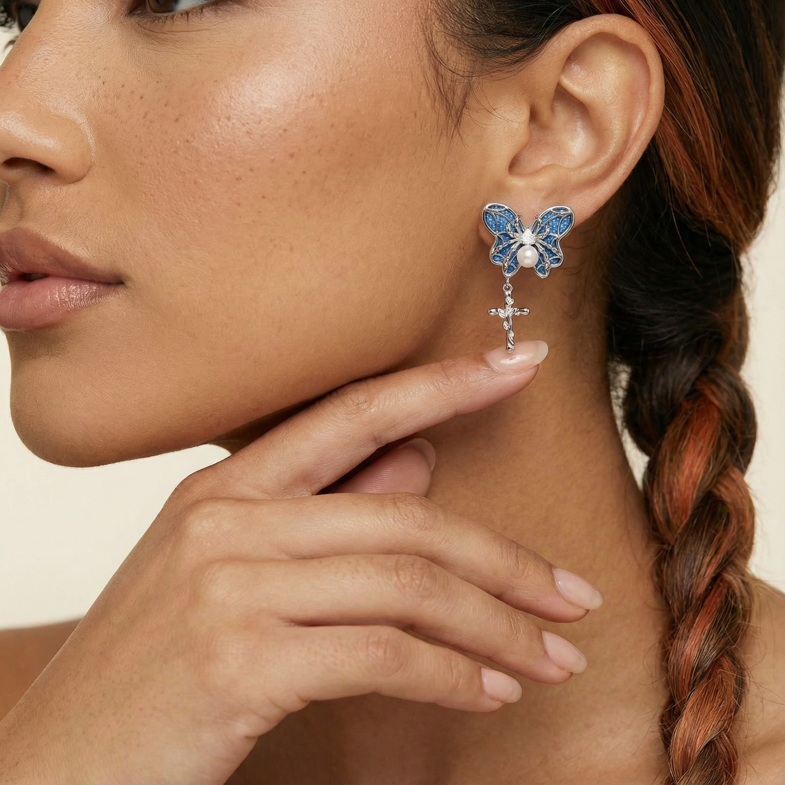 Royal blue denim butterfly earrings with white pearl centers and silver cross charms on white background