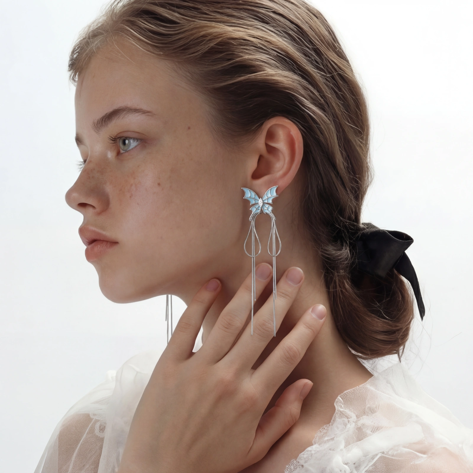 Long silver-tone earrings with powder blue enamel butterfly studs and flowing chain tassels on cream background