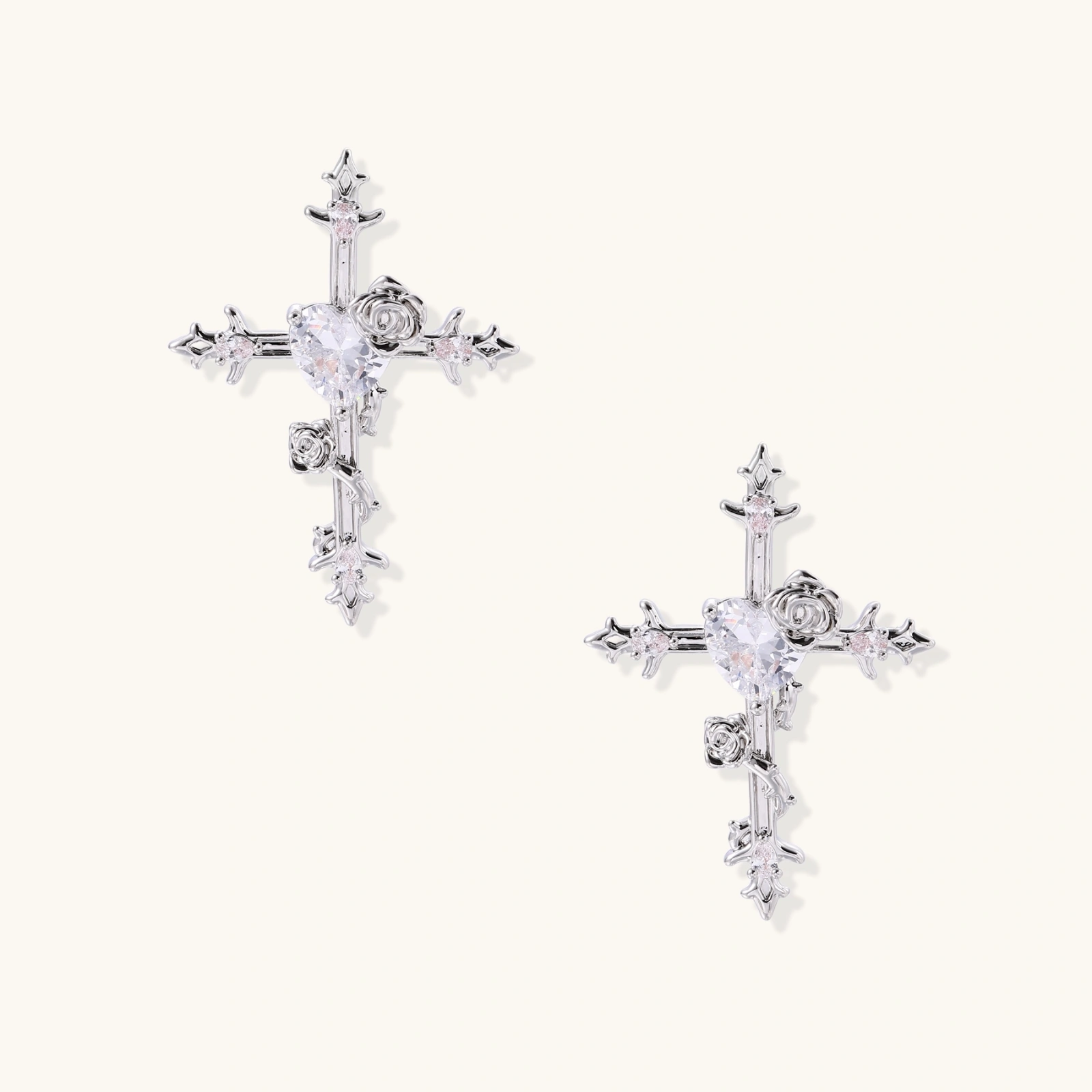 Ornate gold plated cross drop earrings with rose details and sparkling zirconia stones on white background.