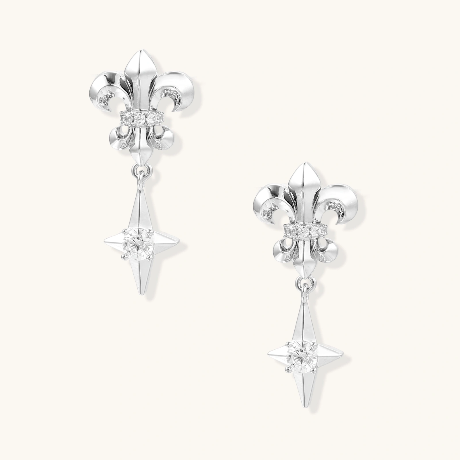 Silver fleur-de-lis drop earrings with geometric star and central crystal on white background