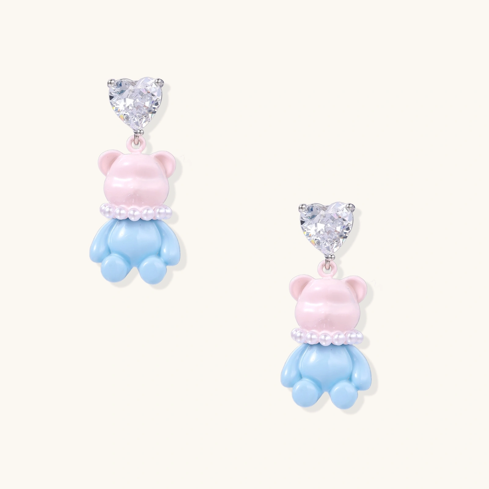 Dangle earrings with heart-cut zirconia studs and pastel teddy bear charms with pearl necklace details