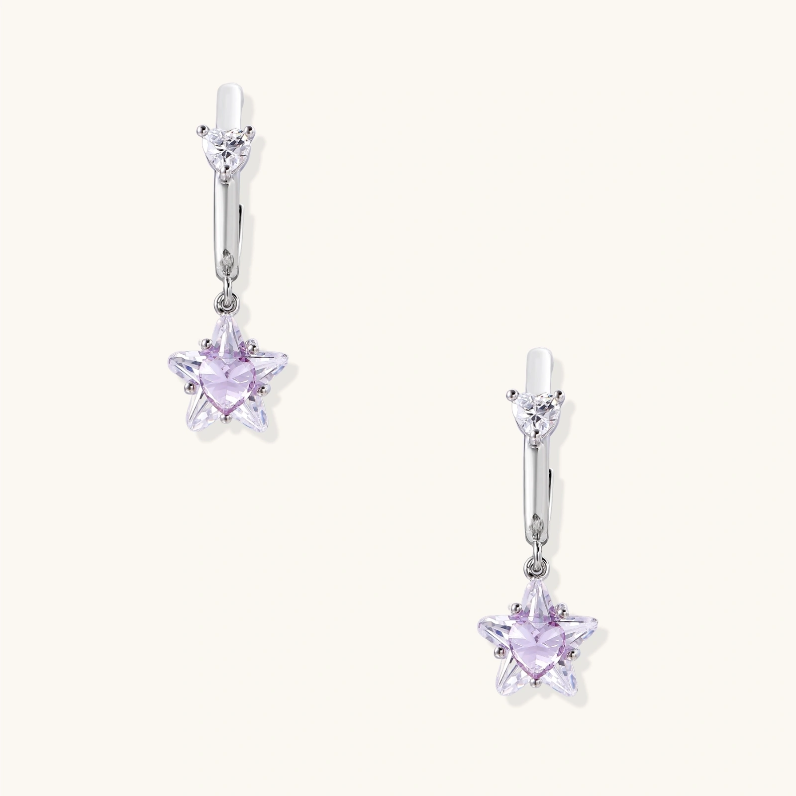 White gold plated huggie earrings with clear CZ accents and dangling lavender star-shaped crystals on cream background
