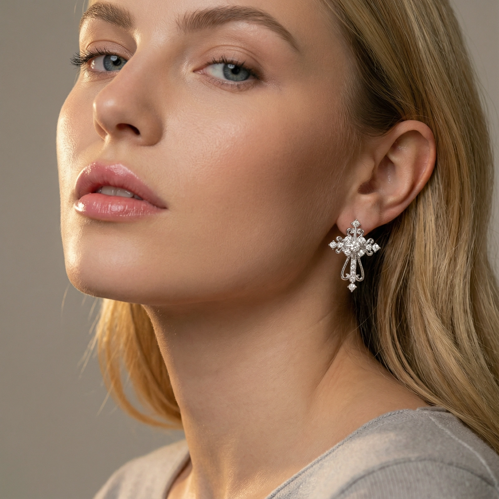 White gold-plated baroque cross studs with zirconia stones and ornate scrollwork on cream background.