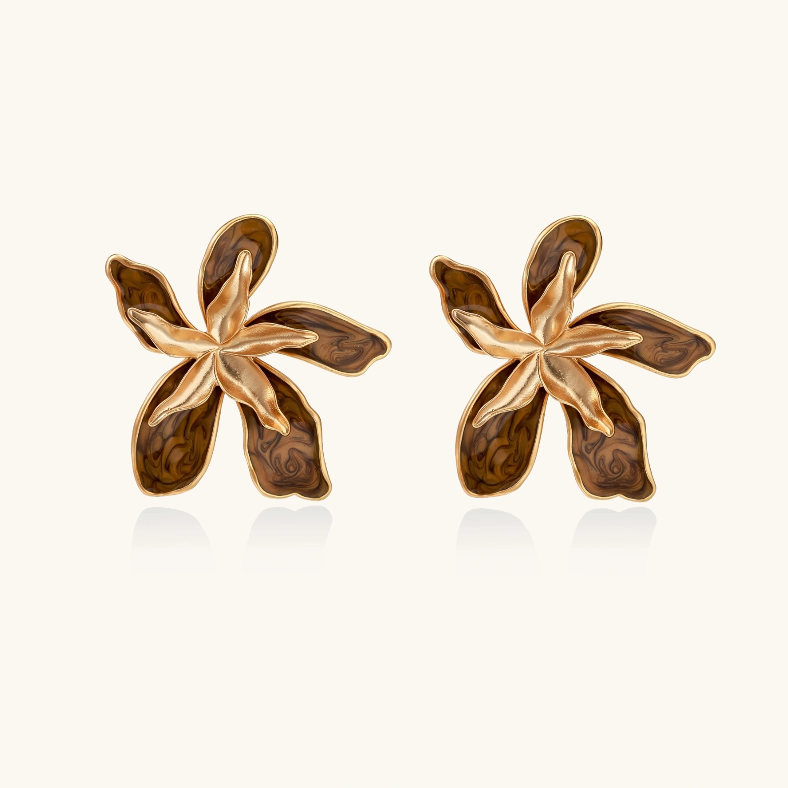 Gold-plated brass flower earrings with brown tortoiseshell enamel petals on cream background