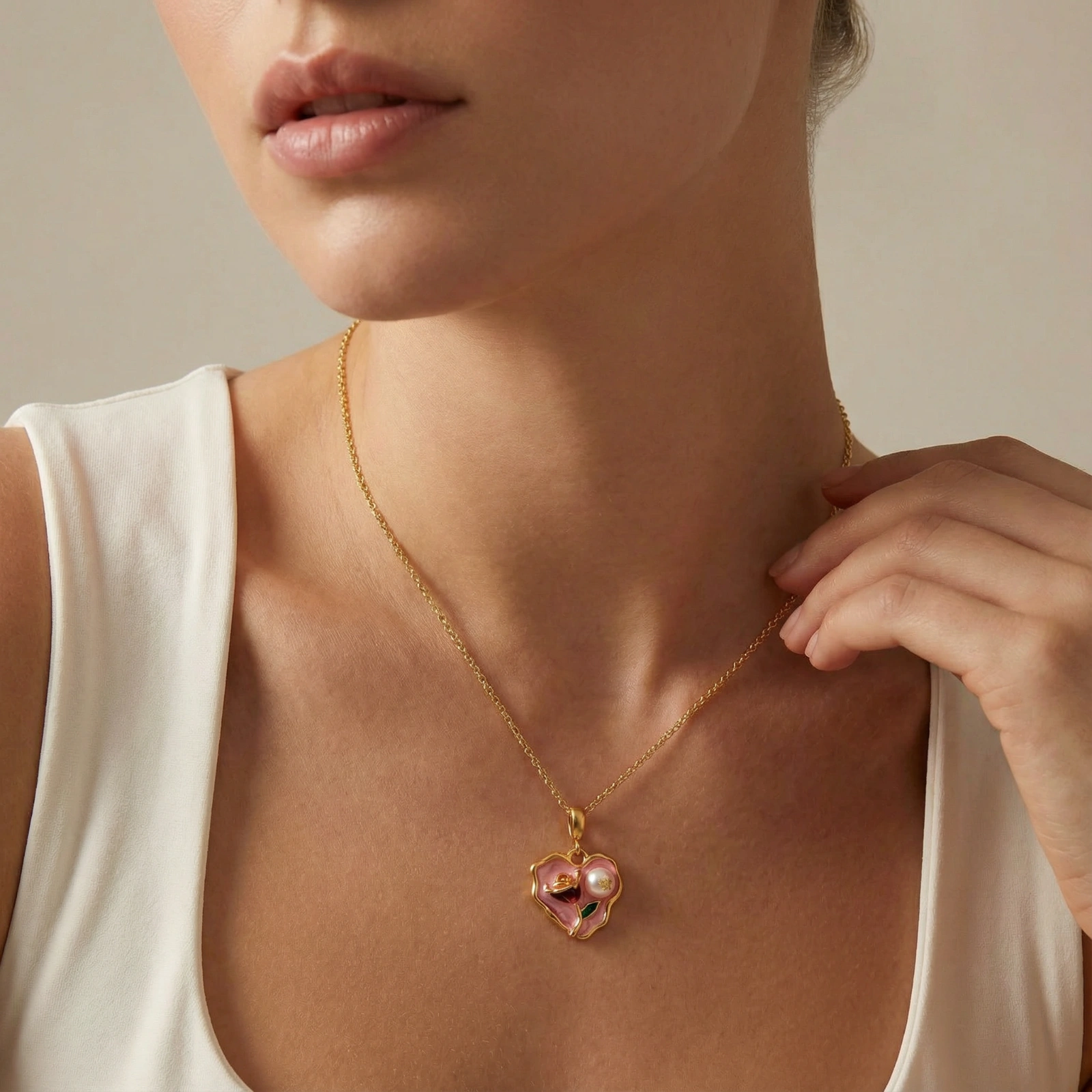 Heart-shaped pendant with pink enamel, rose design, freshwater pearl flower, and gold scalloped frame on delicate chain