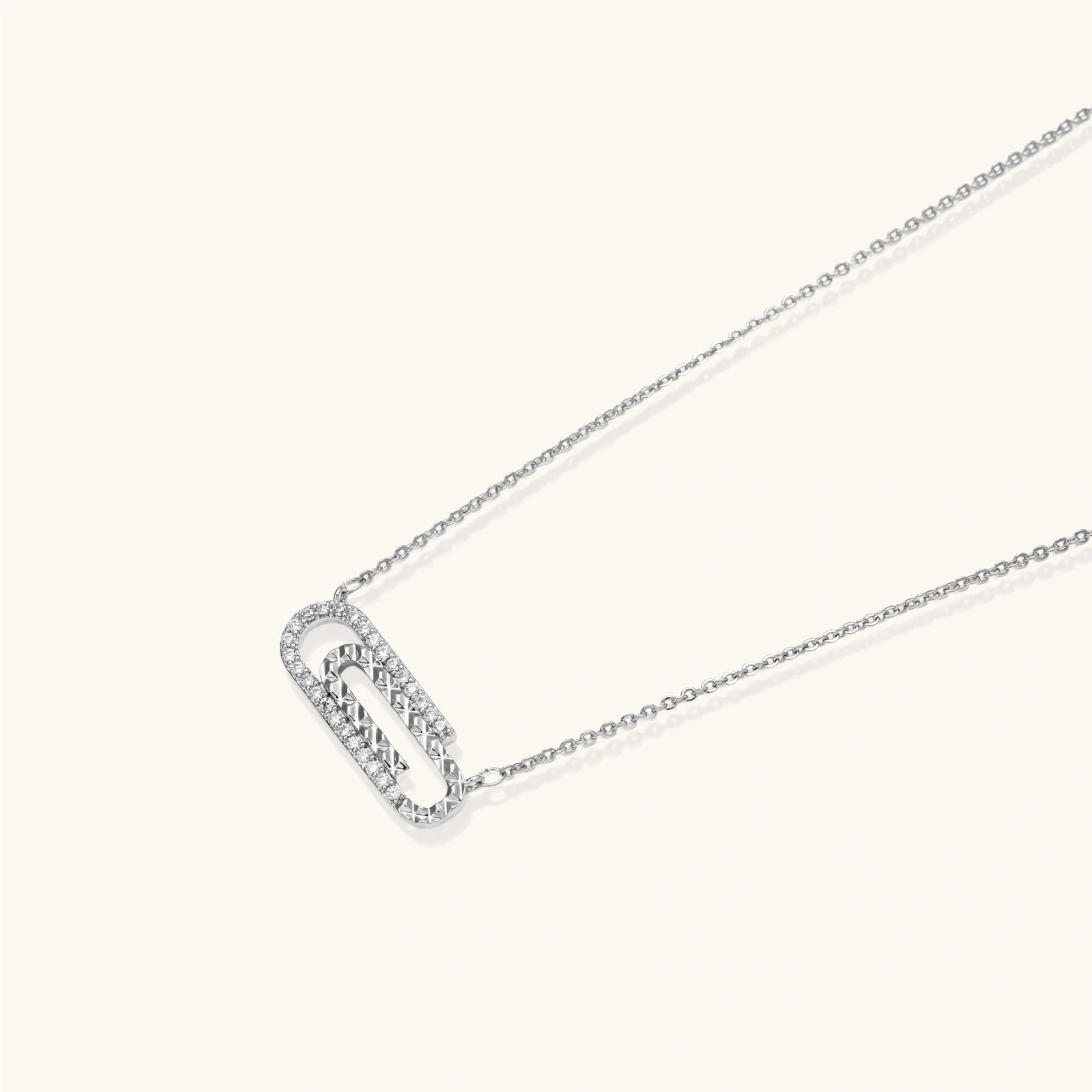 White gold plated necklace with dual-frame geometric pendant featuring crystal pavé border on pale background.