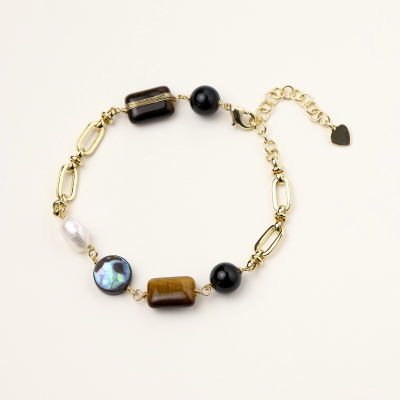 Gold chain bracelet with tiger's eye, obsidian, pearl, and iridescent abalone stones on cream background.