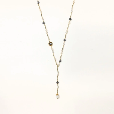 Y-shaped gold-plated necklace with white and gray freshwater pearls on cream background, showing adjustable drop design.