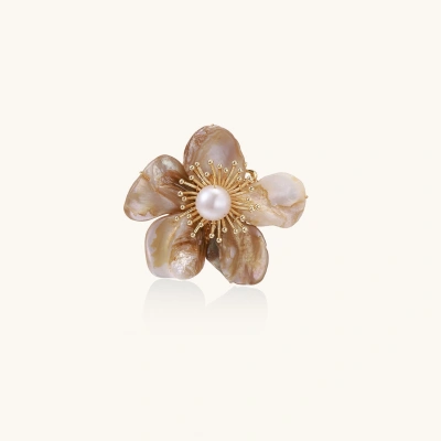 Flower-shaped brooch with iridescent shell petals, freshwater pearl center, and gold-plated radiating details.