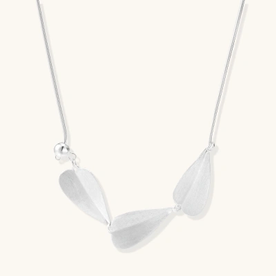 Minimalist sterling silver necklace with three brushed leaf-shaped pendants on delicate chain against white background