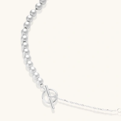 Long sterling silver beaded necklace with graduated sphere design, toggle clasp, and delicate chain extension on white background