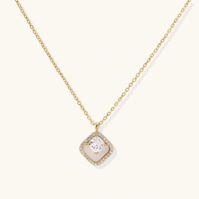 Gold quatrefoil pendant with crystal center on iridescent mother-of-pearl base, adjustable gold chain on cream background