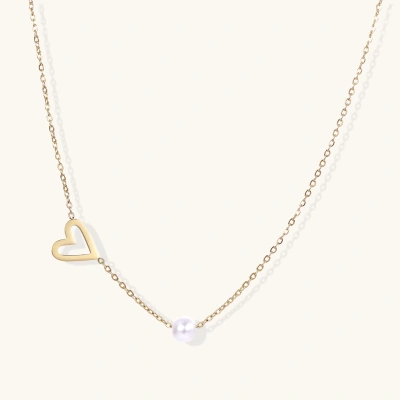 Delicate gold necklace with open heart charm and white pearl bead on fine chain against cream background