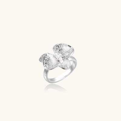 Silver-toned orchid ring with textured petals, pearl center accents, and sparkling zirconia stones on white background.