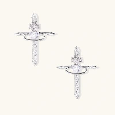 White gold plated cross earrings with orbital ring & zirconia stones on cream background