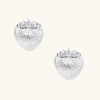 White gold-plated shell-textured stud earrings with three zirconia crystals on ridged surface against cream background.
