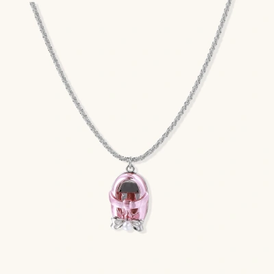 Translucent pink skull pendant with silver bow detail on delicate white gold plated chain against cream background