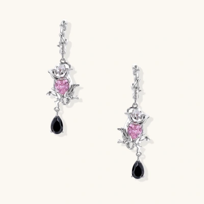 Silver-toned drop earrings with ornate rose design, pink zirconia center, and black teardrop stones on cream background