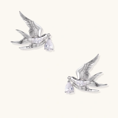 Silver-toned swallow stud earrings with detailed wings carrying teardrop zirconia crystals on white background