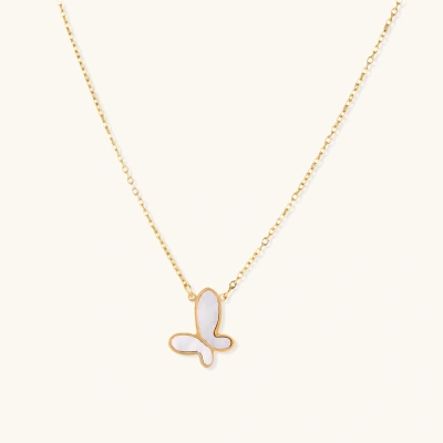 Gold-plated butterfly pendant with iridescent mother of pearl inlay on delicate chain against cream background.