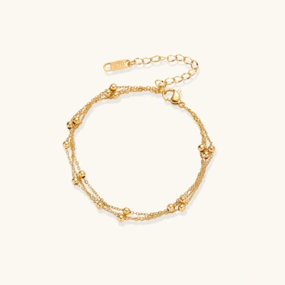 Three-strand gold-plated bracelet with clustered ball beads and adjustable clasp on cream background