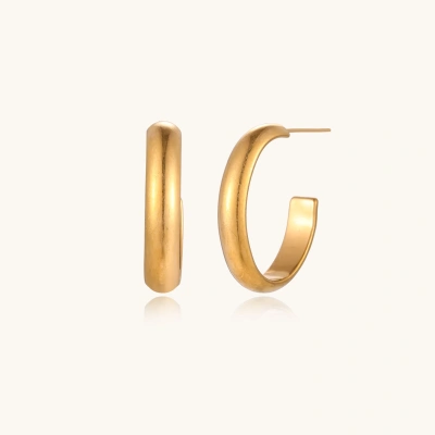 Chunky tubular hoop earrings in warm 14K gold-plated finish with smooth polished surface on cream background.