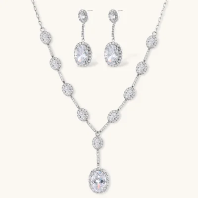 Elegant white gold plated jewelry set with oval cubic zirconia stones in halo settings, featuring Y-necklace and drop earrings.
