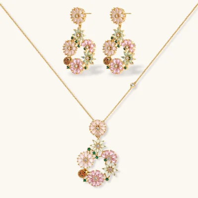 14K gold plated jewelry set with pink and green cubic zirconia flowers arranged in wreath design on cream background