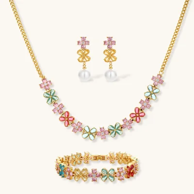 Gold-plated jewelry set with pink, turquoise and red flower-shaped cubic zirconia stones, featuring necklace, earrings and bracelet.