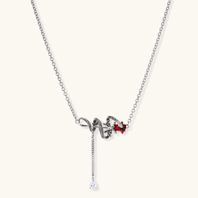 Detailed eco-brass serpent pendant necklace with red zirconia stone and crystal drop tassel on adjustable chain