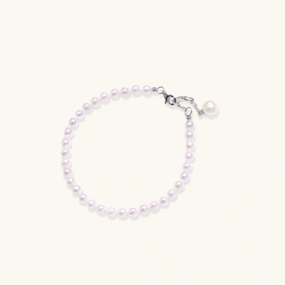 Adjustable bracelet featuring lustrous freshwater pearls with rhodium-plated sterling silver clasp on cream background.