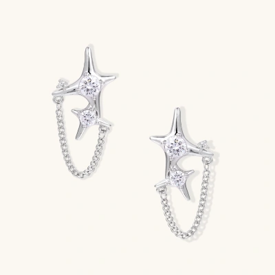Silver star studs with crescent moon cutouts and zirconia stones connected by delicate chains on white background