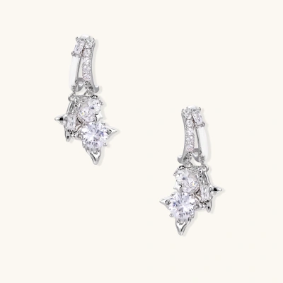 White gold-plated huggie earrings with geometric emerald-cut zirconia clusters in starburst formation on beige background