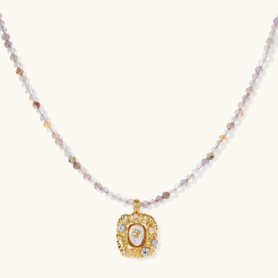 Ornate gold-plated pendant necklace with multicolored gemstone beads in purple, pink and clear tones on white background